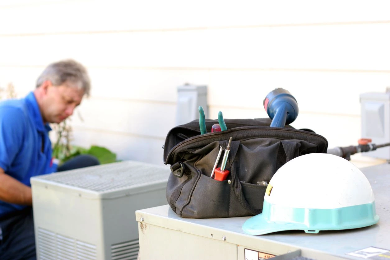 A woman is sitting on the ground with her hair dryer and tools in front of her.